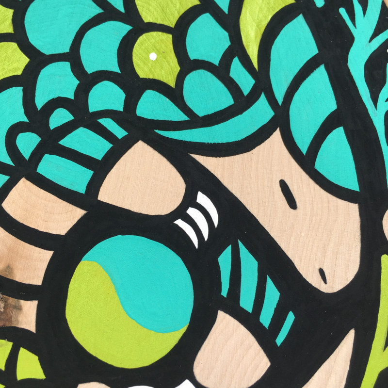 A vibrant pangolin painted with a bright turquoise and lime green sits curled up in the center of a decorative border consisting of vines, leaves, and phases of the moon on a black background.