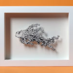 Daria Aksenova. Hand-cut illustration of a space cloud shaped like a fish suspended in a shadowbox structure.