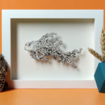 Daria Aksenova. Hand-cut illustration of a space cloud shaped like a fish suspended in a shadowbox structure.