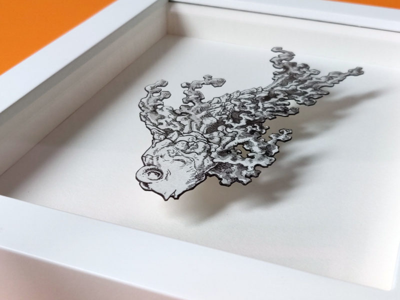 Daria Aksenova. Hand-cut illustration of a space cloud shaped like a fish suspended in a shadowbox structure.