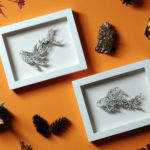 Daria Aksenova. Hand-cut illustration of a space cloud shaped like a fish suspended in a shadowbox structure.