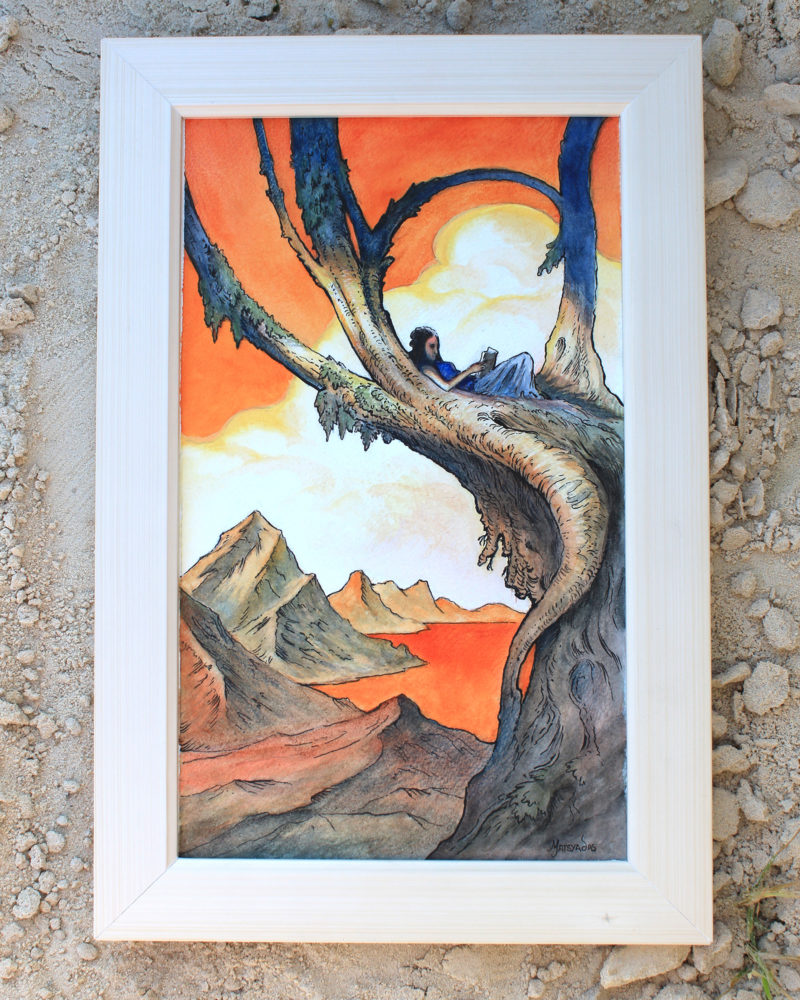 Framed painting of a orange and blue landscape with a person laying on the branches of a tree leaning to the right. There are mountains and a white cloud on the back. The painting stands on a sand floor,