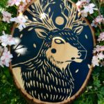 A painting on a wood slice featuring a featuring an elk with tree-like antlers and a full moon as a crown.