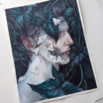 Photograph of a watercolor portrait of a pale person in profile against a dark background. They are surrounded by dark teal leaves, one of which covers the figure's eye. White moths are on the person's face swarming towards a patch of exposed facial muscles on the figure's cheek.