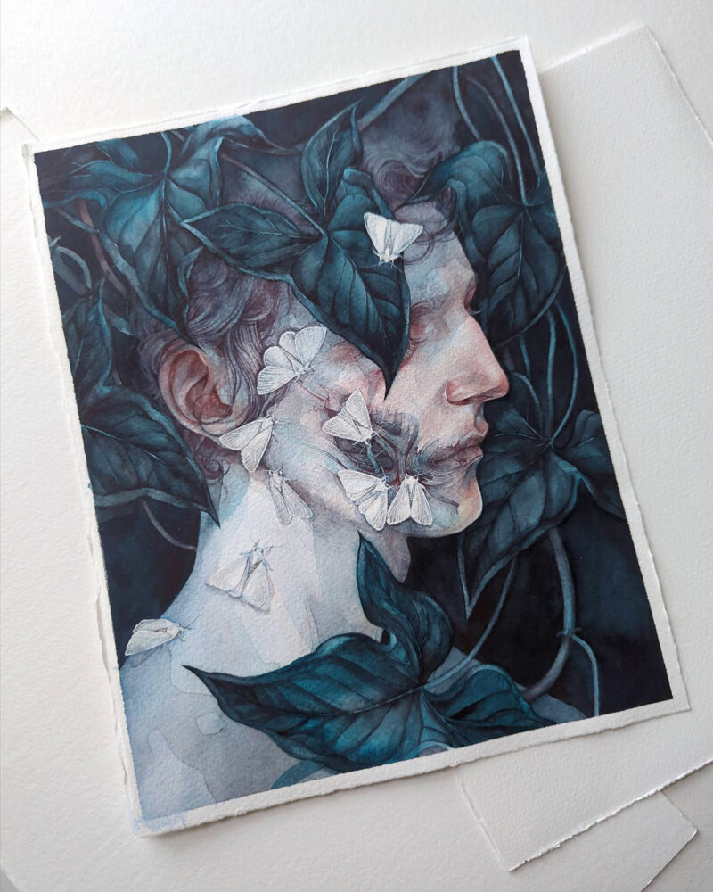 Photograph of a watercolor portrait of a pale person in profile against a dark background. They are surrounded by dark teal leaves, one of which covers the figure's eye. White moths are on the person's face swarming towards a patch of exposed facial muscles on the figure's cheek.