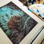 photograph of an ink and watercolor illustration of a brown bear sleeping peacefully inside a cave with a crescent moon and stars overhead.