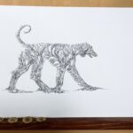 ink drawing of an afghan hound silhouette made of a bunch of trees in a forest - staged in a warm area with a fan, and bracelet