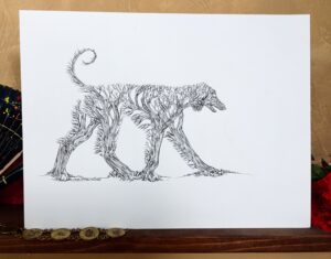 ink drawing of an afghan hound silhouette made of a bunch of trees in a forest - staged in a warm area with a fan, and bracelet