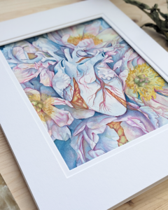 A watercolor painting of a blue heart is tangled within a cluster of blue peonies.