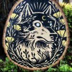 Photo of the painting itself propped up against a sequoia tree with greenery in the front. The painting features a wolf that has a gold crescent moon mark on her forehead, and is surrounded by golden California poppies.