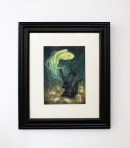 Framed image of a black cat batting at ghost during a seance.