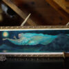 The West Wind, a painting of blue and yellow and soft pink, depicting an anthropomorphized vision of the west wind flying over fjords at night under the full moon. The painting is framed in a gilded frame with small flower details. A cat walks down the stairs behind the painting.