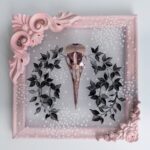 Pink metallic filigreed crow skull surrounded by black leaves