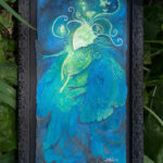 Watercolor painting of a vibrant blue and yellow moth woman, framed in black. She has small moth lights floating around her.