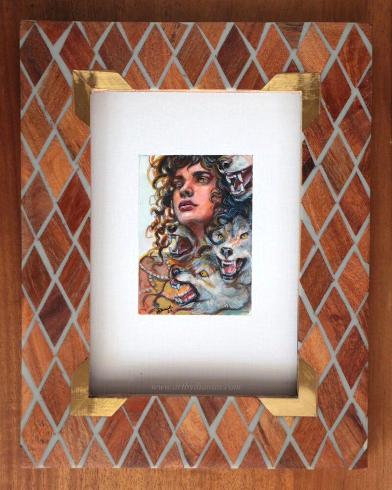 A miniature painting with a curly hair woman looking hopeful. Surrounded by angry wolves that seem to be coming out of her. This photo shows the painting with a frame.