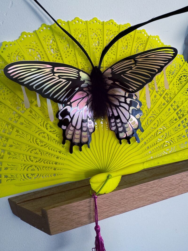 Pink iridescent moth on neon vintage fan