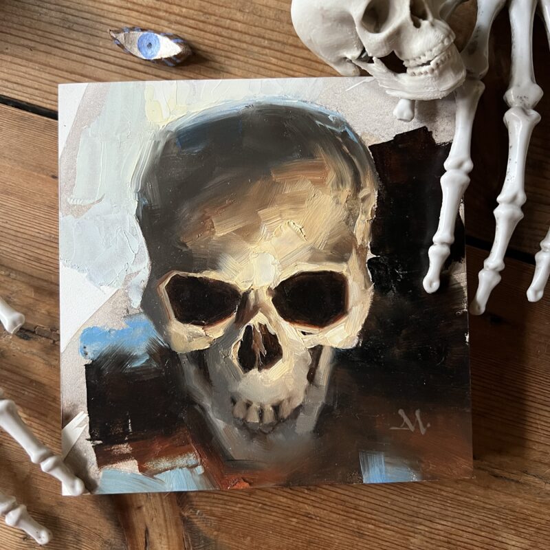 Oil painting of a skull by Greg Manchess, on a table with plastic bones around.