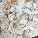 A close up of a drawing, showing hands ripping away fabric with creepy faces and flowers.