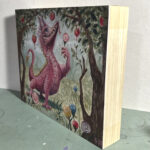 Three quarter view of original painting of the Candy Cane Dragon. Depicts a pink dragon with candy cane horns. He holds a lollipop flower in his hand and is surrounded by trees bearing candied apple fruit.