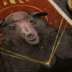 A painting of a sheep with red eyes. The background is solid red with black drips at the top. Above the sheep's head is a broken gold crown. A small gold star and four gold lines burst out from the sheep's chest.