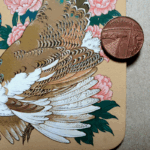 Detail of the wing and tail feathers from a painting on a square coaster of a pied peahen surrounded by pink peonies, photographed with a penny for scale.