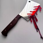 Large silver cleaver with wooden handle, dripping blood
