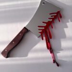 Large silver cleaver with wooden handle, dripping blood