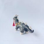 Sgraffito ceramic dragon sculpture done with black and orange underglazes. The piece features my signature California Poppies motif, gold luster details, and a red tassel hanging from the dragon's mouth.