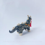 Sgraffito ceramic dragon sculpture done with black and orange underglazes. The piece features my signature California Poppies motif, gold luster details, and a red tassel hanging from the dragon's mouth.