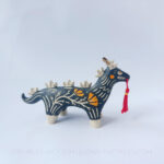 Sgraffito ceramic dragon sculpture done with black and orange underglazes. The piece features my signature California Poppies motif, gold luster details, and a red tassel hanging from the dragon's mouth.