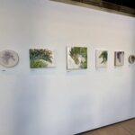 Gallery wall with six floral court dragons on it, from left to right "Calla Queen", "The. Queen of Kelp", "The Pumpkin King", "Knight of Holly", "Prince of Wisteria", and "Lavender Emperor"