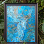 Photo of a painting of a deer in a frame. it is surrounded by plants outside.