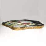 side view of a fantasy borzoi adorned in shining gold is caught in a cameras bright flash while standing in tall grass. painting on a Quatrefoil found object.