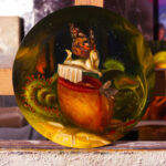 An oil painting of a fairy resting above a pitcher plant leaf with a moth on the edge of its opening. Surrounding the focus of the painting is two Venus fly traps, and a coiled sundew.