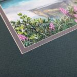 Photo of an artwork showing the close up corner where the signature is in black ink over the plants in the foreground