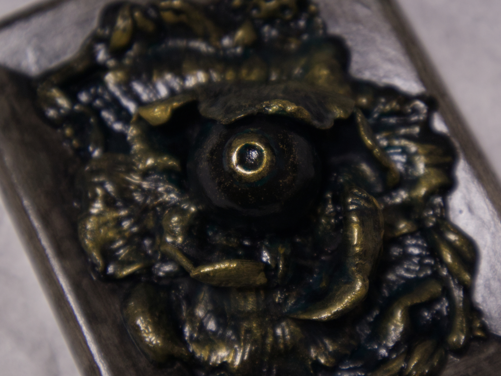 A photo of a sculpture of an eye surrounded by petals, branches, and leaves.