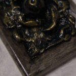 A photo of a sculpture of an eye surrounded by petals, branches, and leaves.