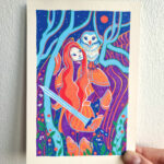 An artwork named "Interlude" is held by the artist's right hand in front of a white wall. It depicts a woman in armor, holding a sword looking up to the moon with an owl perched on her left shoulder. They are framed by trees and flowers with a mountain & sky behind them. The artwork is colored predominantly in blue, orange and violet posca pen with a white border.