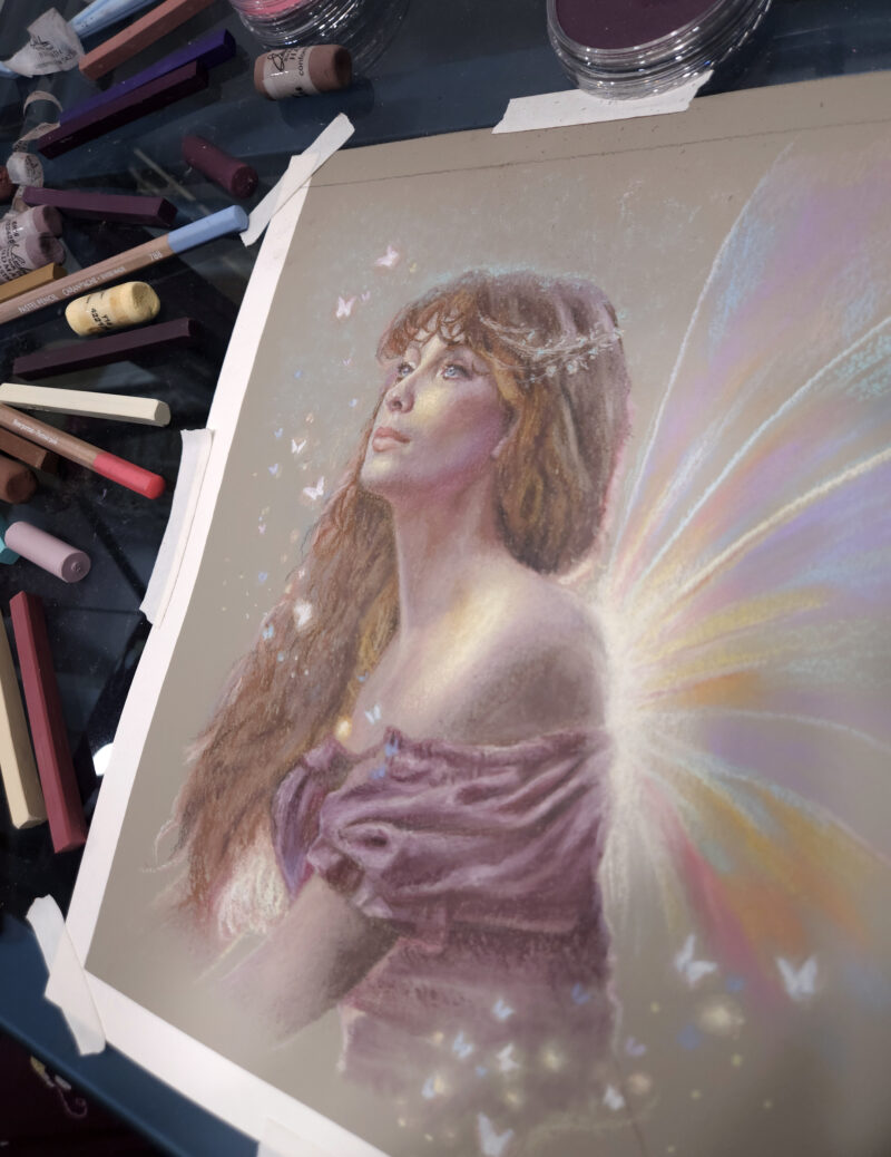 Fairy drawing on a table with pastels