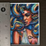 A portrait of Medusa with colorful snakes. Miniature painting. Ruler for scale