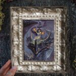 A framed picture of a fire fairy riding a dragon