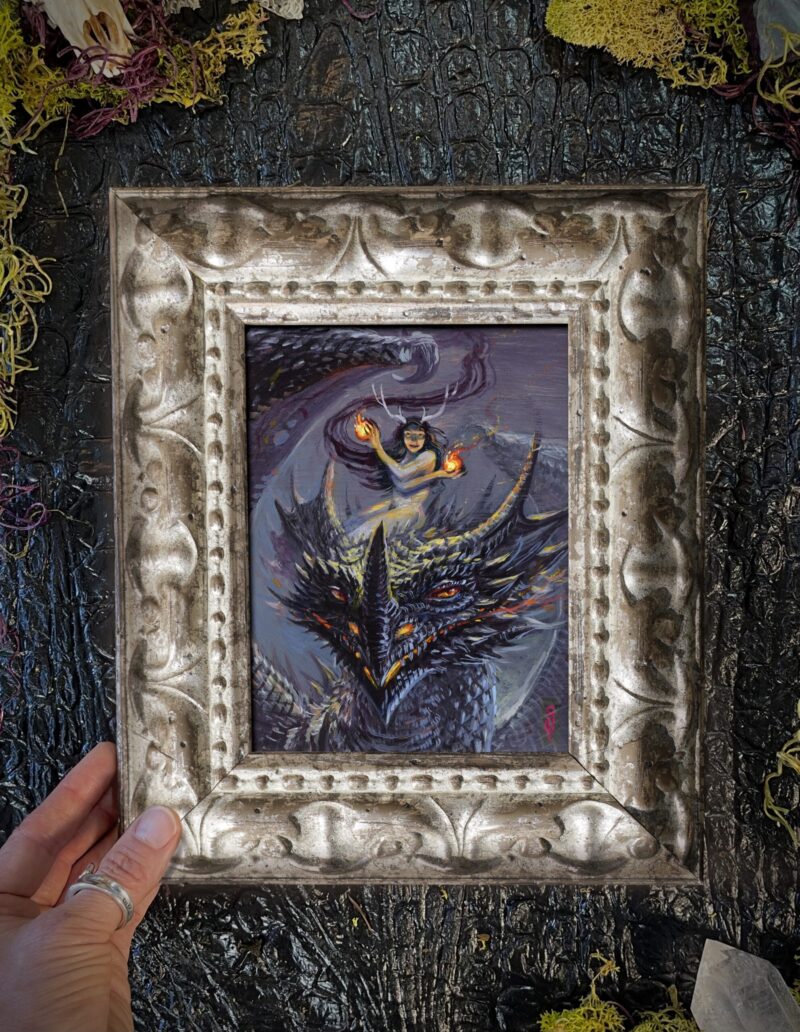 A framed picture of a fire fairy riding a dragon