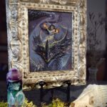 A framed picture of a fire fairy riding a dragon