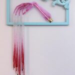 Golden skeletal hand elegantly posed with silver beads dripping from the fingers