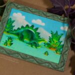 purple and green house plant at the sides of a framed painting of a green and yellow gummie candy adult stegosaur eats a gummie candy fern and a gummie candy baby stegosaur looks up under a blue sky with mountains a puffy white gummie candy clouds
