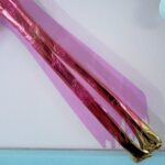 Detail of golden radius and ulna, overlaid with pink, translucent film etched with anemones