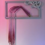 Golden skeletal hand elegantly posed with silver beads dripping from the fingers