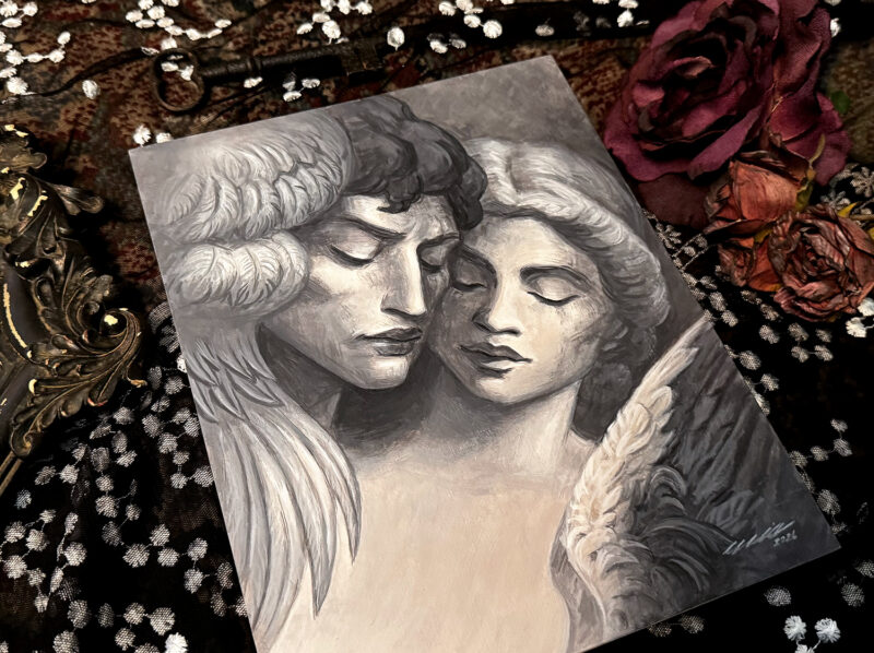 Tilted studio shot of Statue Lovers painting, surrounded by fabric, flowers, frame.