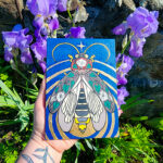 An acryla gouache painting of a lightning bug with gold leaf emanating from its glowing end. The lightning bug is on a blue background and has images of a moonflower plant drawn over its wings and body.