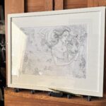 A side shot of framed "Strength" Drawing on a mahogany easel.